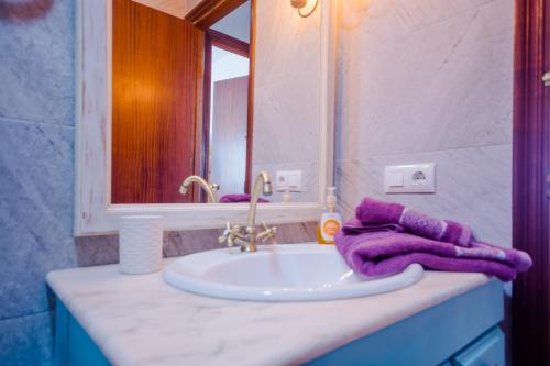 a bathroom sink with a purple towel on it at La Barrosa con vistas al mar in Novo Sancti Petri