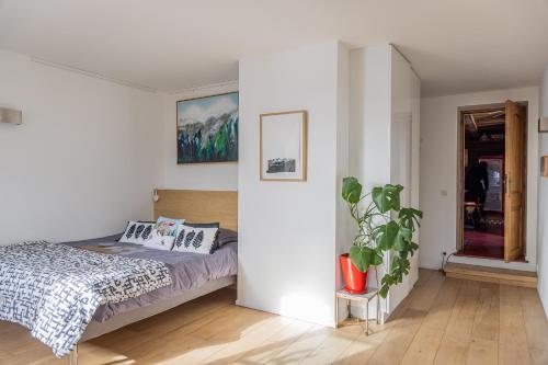 Chalet à Megève-Vauvray - Grands Appartements , vue Mont Blanc في Demi-Quartier: غرفة نوم مع سرير وزرع الفخار