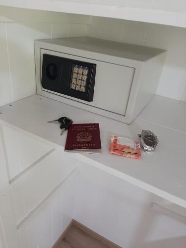 a microwave on a shelf with a book on it at Moana Breeze Rangiroa - Rental car included - Air conditioning - WI-Fi in Tiputa