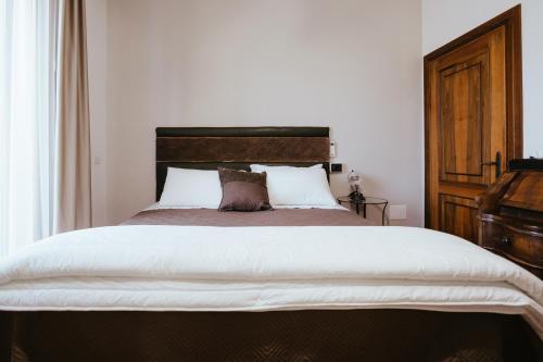 a bedroom with a large bed with a wooden headboard at Locanda Acetaia Malagoli Daniele in Castelfranco Emilia