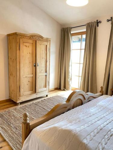 1 dormitorio con 1 cama, armario y ventana en Wohnung in Kirchberg in Tirol, en Kirchberg in Tirol