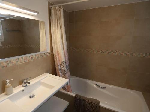 a bathroom with a sink and a tub and a mirror at Villa Marina Calan Blanes in Cala en Forcat
