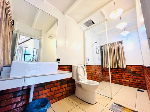 a bathroom with a white toilet and a sink at KASIH SAYANG Farmstay山下人家 in Kluang