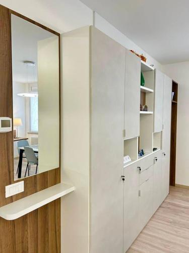 a room with a large mirror and white cabinets at Codroipo square in Codroipo
