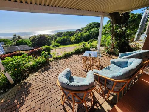 a patio with two chairs and an umbrella at Seaview Villa 25 in Shelly Beach
