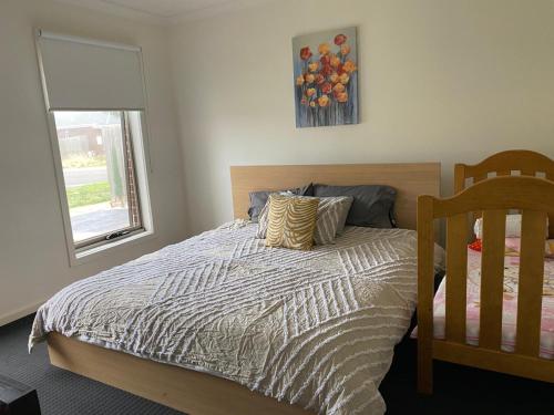 um quarto com uma cama e uma janela em Comfy nest 4 bed room family house em Melton South