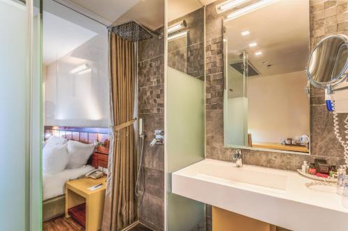 a bathroom with a sink and a mirror at Haifa Bay View Hotel By AFI Hotels in Haifa