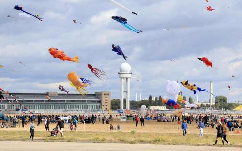 a group of people flying kites in a field at Schillinger-Berlin - dance, sleep, repeat! in Berlin