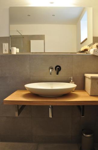 a bathroom with a white sink on a wooden counter at Waschhaus in Ditfurt