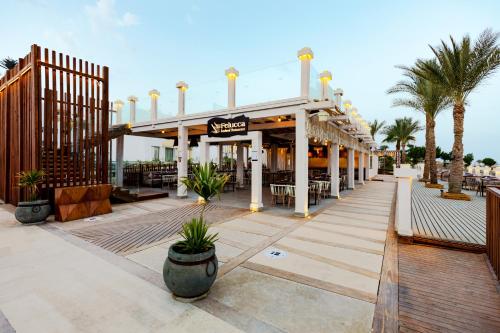 a resort with a restaurant with palm trees at Sunrise Diamond Beach Resort -Grand Select in Sharm El Sheikh