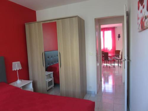 a bedroom with red walls and a red bed and a dining room at NICE NORD 2 PIECES CALMES,WIFI,CLIM,BALCON,PARKING in Nice
