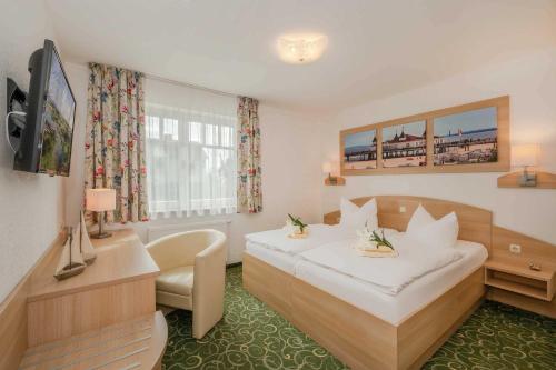 a hotel room with a white bed and a desk at Gasthaus Natzke in Usedom Town