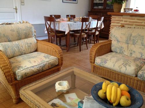 a living room with a table with a bowl of fruit at Le gîte de Pouzatel proche Château de Bonaguil in Fumel