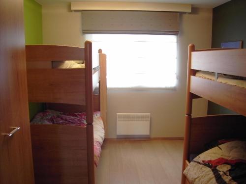 een kamer met twee stapelbedden en een raam bij Luxe appartement, zeezicht, garage en topligging in Oostende
