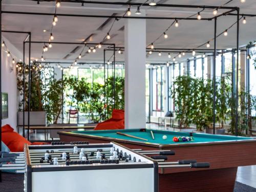 a pool table in a room with plants at Greet hotel Darmstadt - an Accor hotel - in Darmstadt