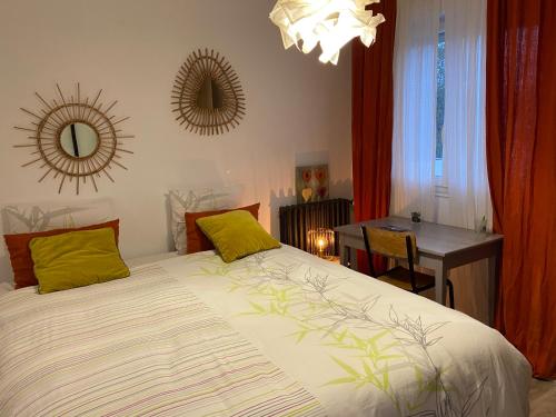 a bedroom with a bed and a table and a mirror at Les Logis du Forgeron in Saint-Jean-des-Mauvrets