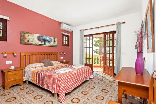 a bedroom with a bed with a red wall at Villa Nineta in Son Bou