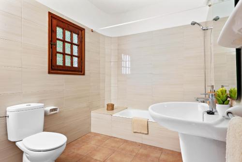 uma casa de banho branca com um WC e um lavatório em Villa Nineta em Son Bou