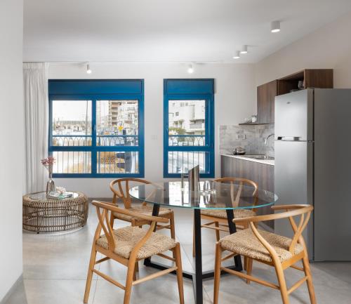 a kitchen with a glass table and chairs and a refrigerator at AMALON Boutique Apartments in Jerusalem