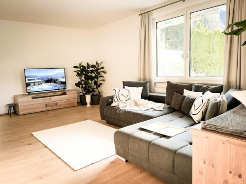 a living room with a couch and a flat screen tv at PAM Apartments in Kaprun