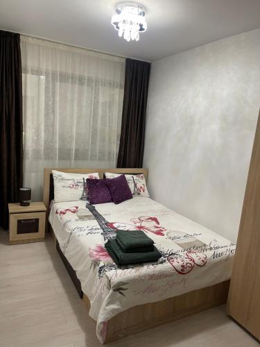Un dormitorio con una cama con una guitarra. en Discret Apartament One, en Târgovişte