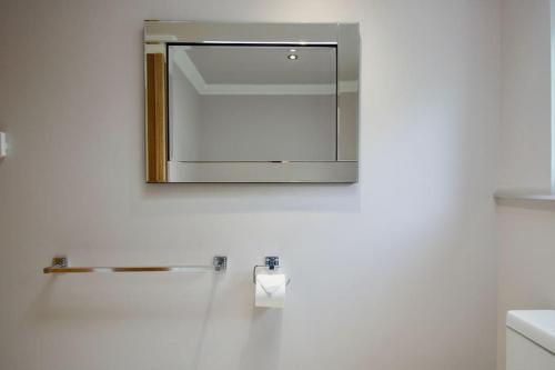 een spiegel aan een muur in een badkamer bij The Old Schoolhouse Lochearnhead in Lochearnhead