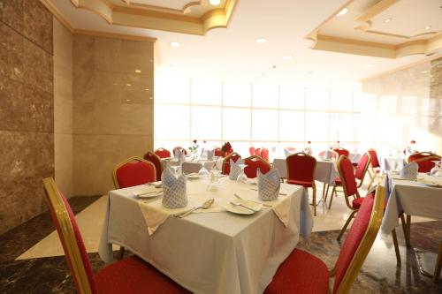 أبراج الريان المكية 1 في مكة المكرمة: غرفة طعام مع طاولات وكراسي حمراء