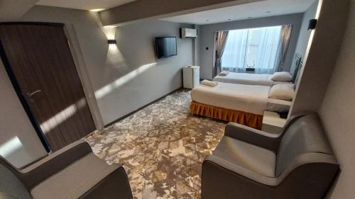 ein Hotelzimmer mit 2 Betten und einem großen Fenster in der Unterkunft Sur Hotel in Sur