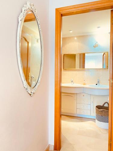 a bathroom with a mirror and a sink at Beach Penthouse Apartment in Jávea