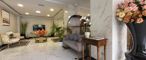 a living room with a couch and flowers on the wall at Baan Thanakul Residences in Samutprakarn
