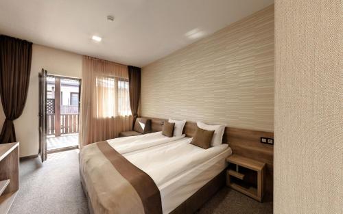a hotel room with a large bed and a window at Complex YustinaVillas in Ustina
