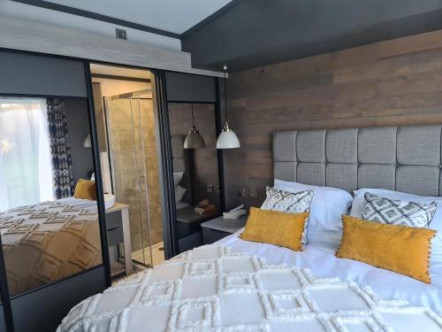 een slaapkamer met een groot wit bed met gele kussens bij Mawgan Pads Lazy Days Lodge in Mawgan Porth