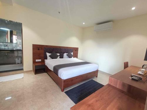 ディブルガルにあるHOTEL GOLDEN ORCHIDのベッドルーム(大型ベッド1台、テーブル付)