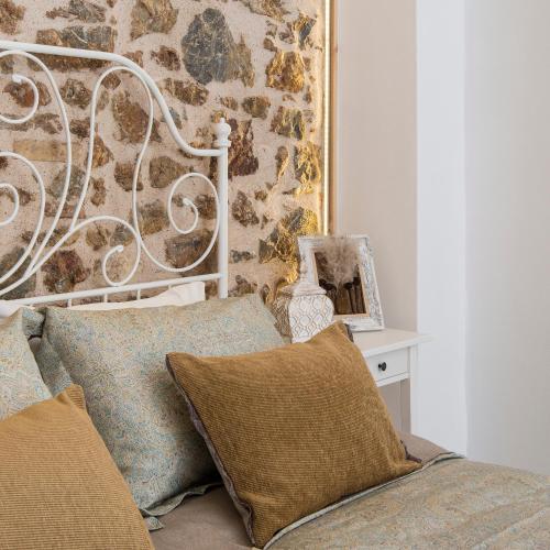 a bed with two pillows in a room with a wall at Athena Luxury Studios in Athens