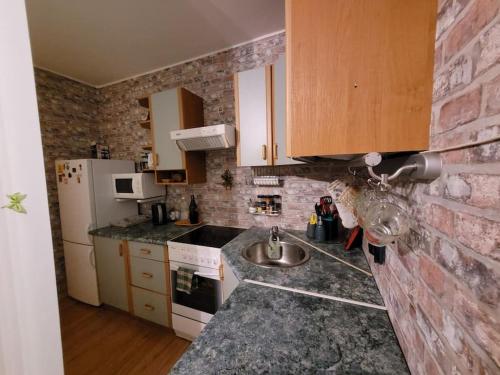 eine Küche mit Spüle und Ziegelwand in der Unterkunft Cozy 2-room studio in Tallinn