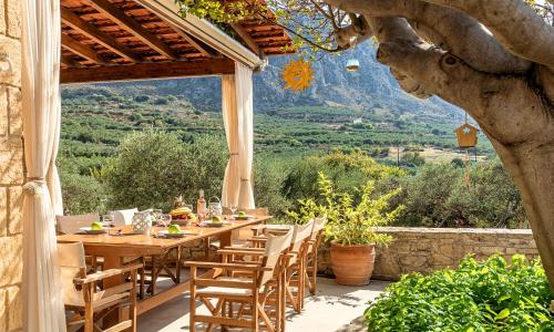 a wooden table and chairs on a patio with a view at Cretan Kera Villa Heated Pool in Kerá