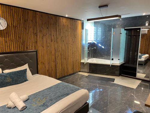 um quarto com uma cama e uma cabina de duche em vidro em Lago Suites Hotel em Jerusalém
