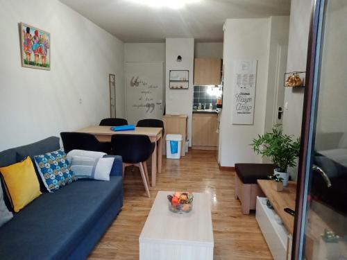 a living room with a blue couch and a table at T2 Calme assuré face à la pique les Ramel in Luchon