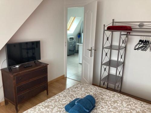 a bedroom with a bed with a tv and a dresser at T2 cosy bien équipé climatisé pkg ext gratuit in Fleury-les-Aubrais