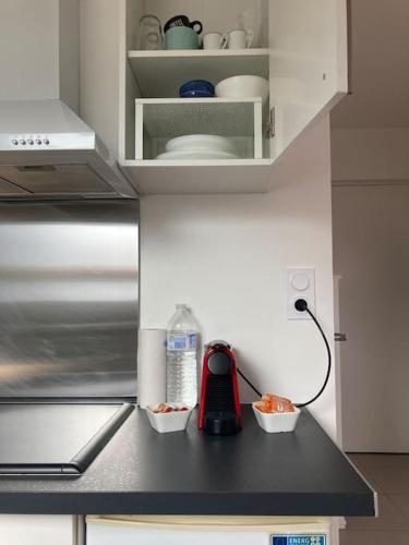 un comptoir de cuisine avec deux bols de nourriture et un téléphone dans l'établissement T2 cosy bien équipé climatisé pkg ext gratuit, à Fleury-les-Aubrais