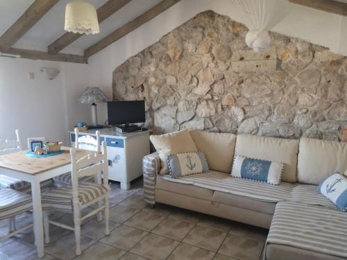 - un salon avec un canapé et un mur en pierre dans l'établissement Charming dalmatian apartment with panoramic view, à Tkon