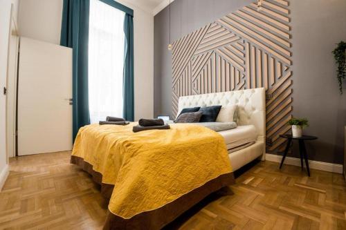 a bedroom with a bed and a couch with a yellow blanket at Deluxe Quentin Home next to the Fashion Street in Budapest