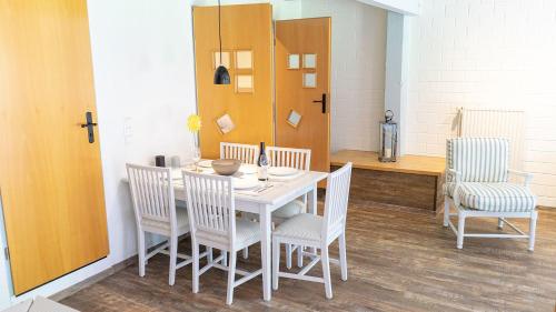 a dining room with a white table and chairs at Warfblick - Landlust Osterwarf in Norddeich