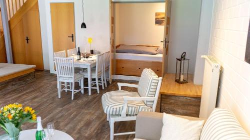 a room with a table and chairs and a bedroom at Warfblick - Landlust Osterwarf in Norddeich