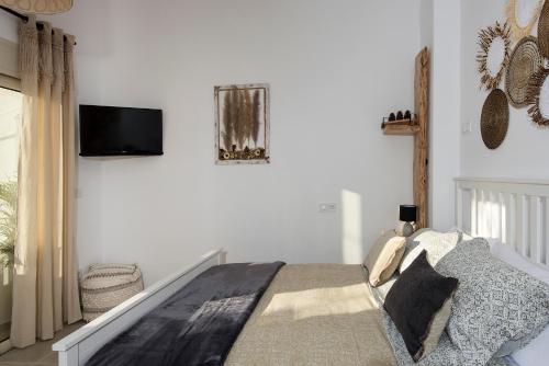 - une chambre avec un lit et une télévision murale dans l'établissement Athena Luxury Studios, à Athènes