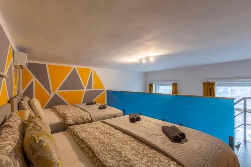 1 dormitorio con 2 camas y pared azul en Global Living - Deluxe Rakoczi Residence By Bella, en Budapest
