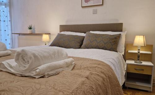 sypialnia z dużym łóżkiem z kocami i poduszkami w obiekcie Spacious 1 Br Near Lincoln City Centre Amenities w mieście Lincoln