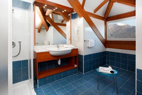 y baño con lavabo y ducha. en Aparthotel Englovacanze, en Riva del Garda