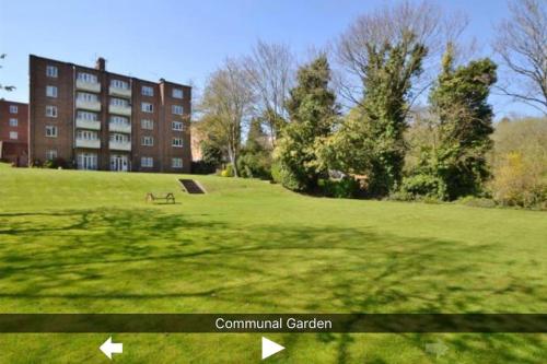 a park with a bench in front of a building at Modern Central Apartment with Free Parking in Southampton