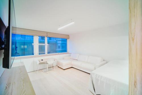 ヘルシンキにあるCentral Studio Nordic Styleの白いリビングルーム(白いソファ、窓付)